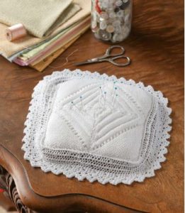 A counterpane pincushion, inspired by the pattern of an heirloom counterpane baby blanket in the collection of the Huron County Museum & Historic Gaol
